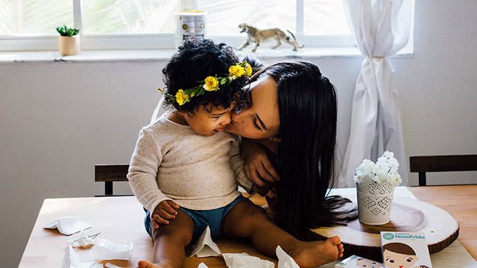 A mother kissing her baby's cheek.