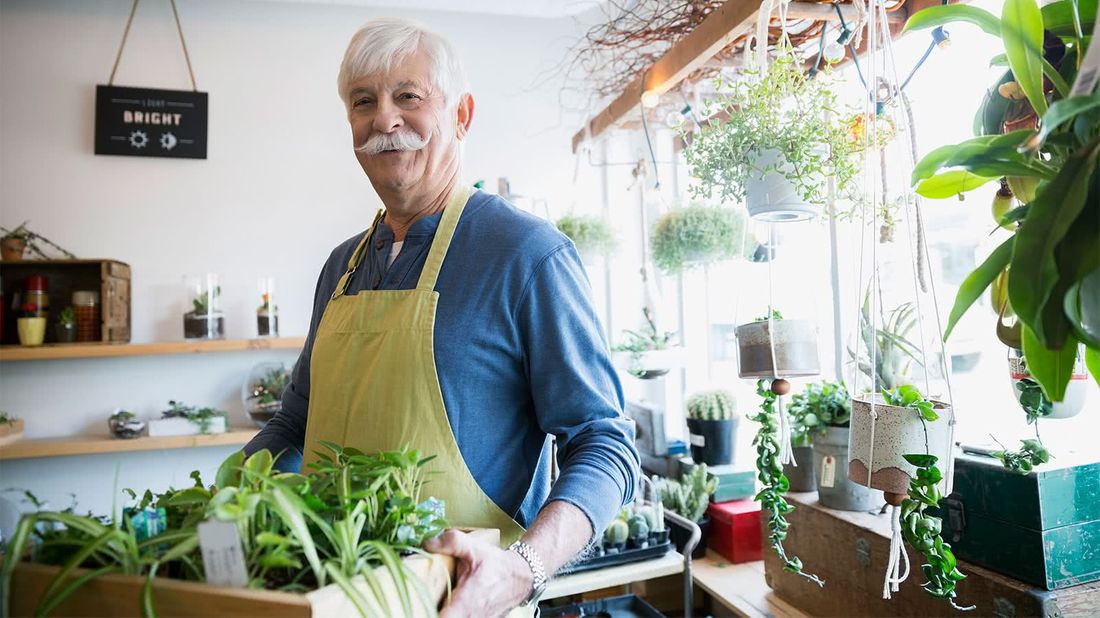 Man holding plants wondering when is the right time to retire