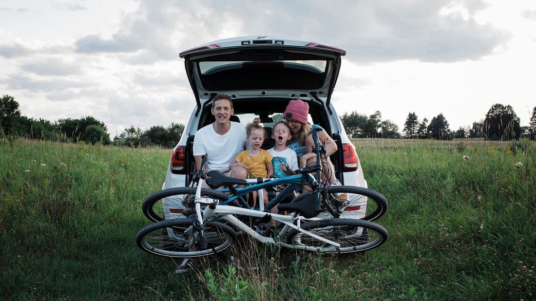 family unloading car trunk to go on bicycle ride