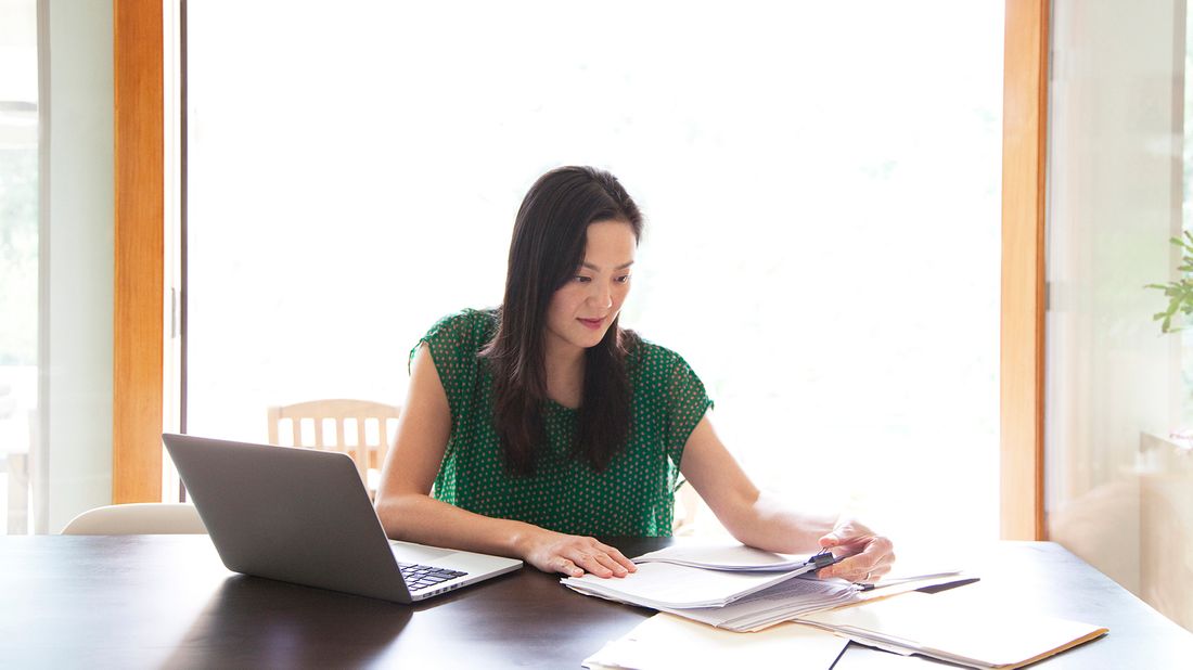 Woman reviewing finances in front of her laptop