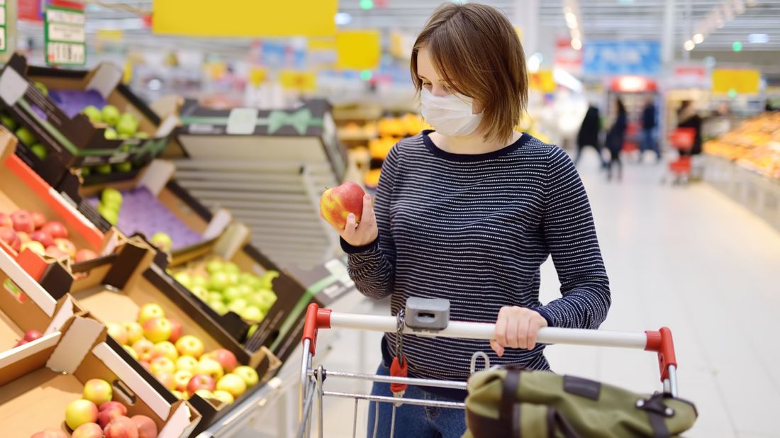 Woman grocery shopping whose budget is impacted by the coronavirus.