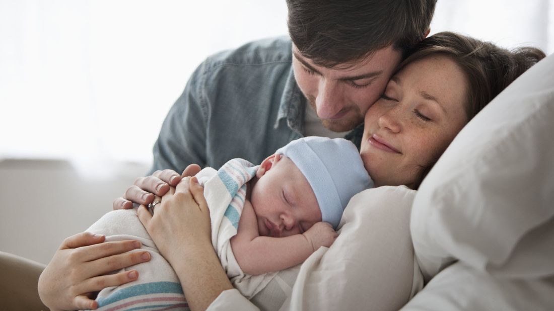 Mother and father holding new baby.