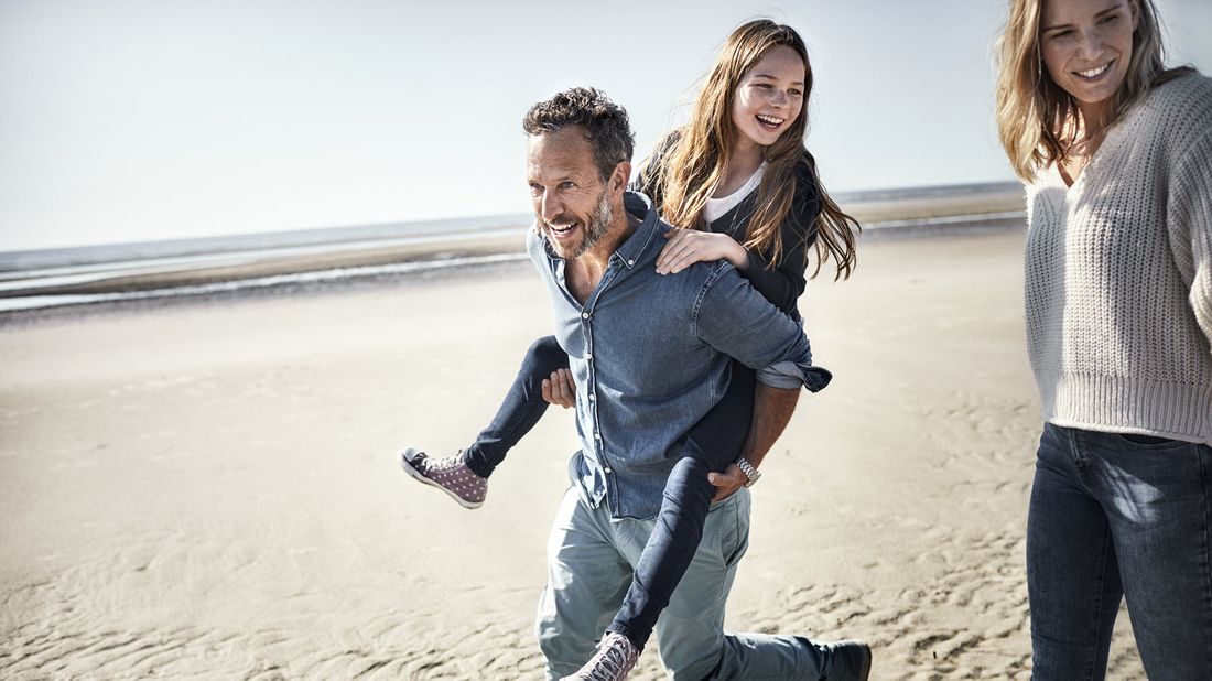 Family that just got its first permanent life insurance policy at the beach.