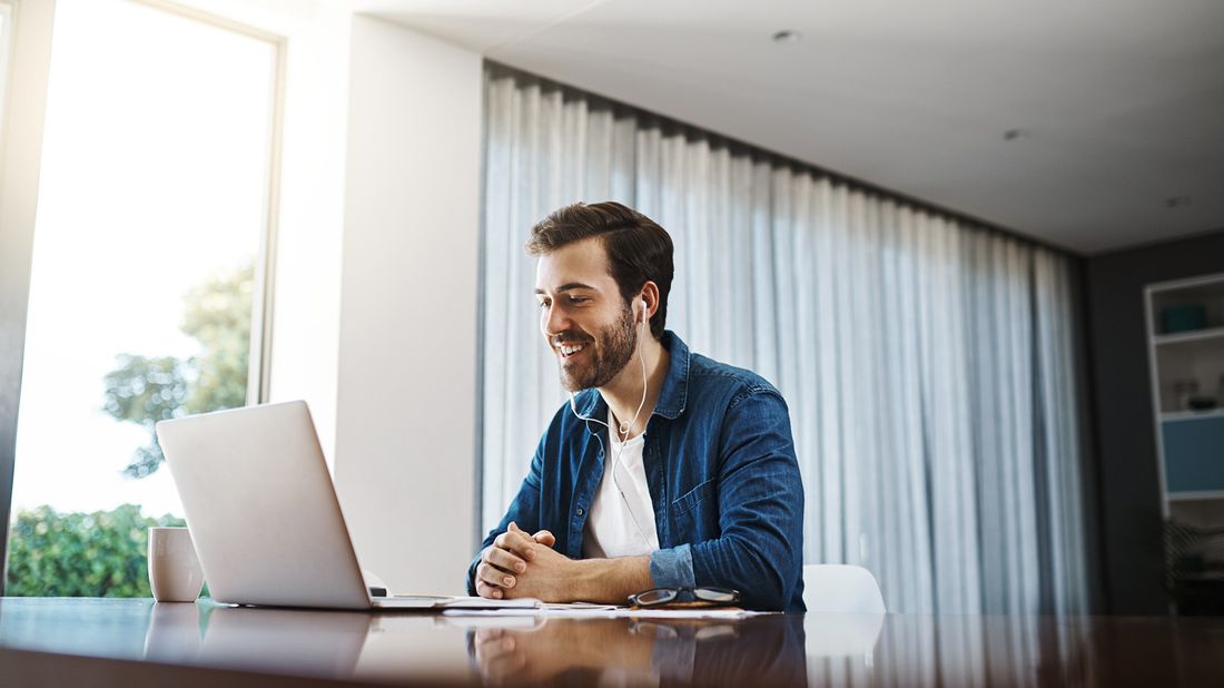 man taking business call on laptop at home