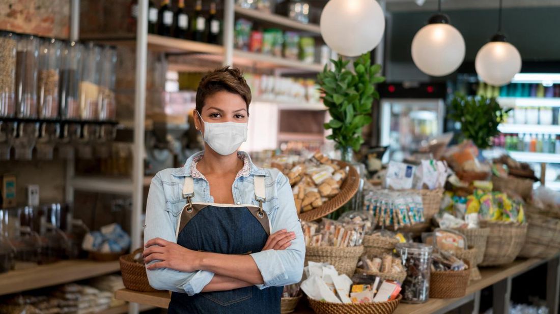 female small business owner in store wearing a face mask