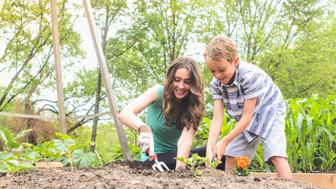 mother and son planting a garden