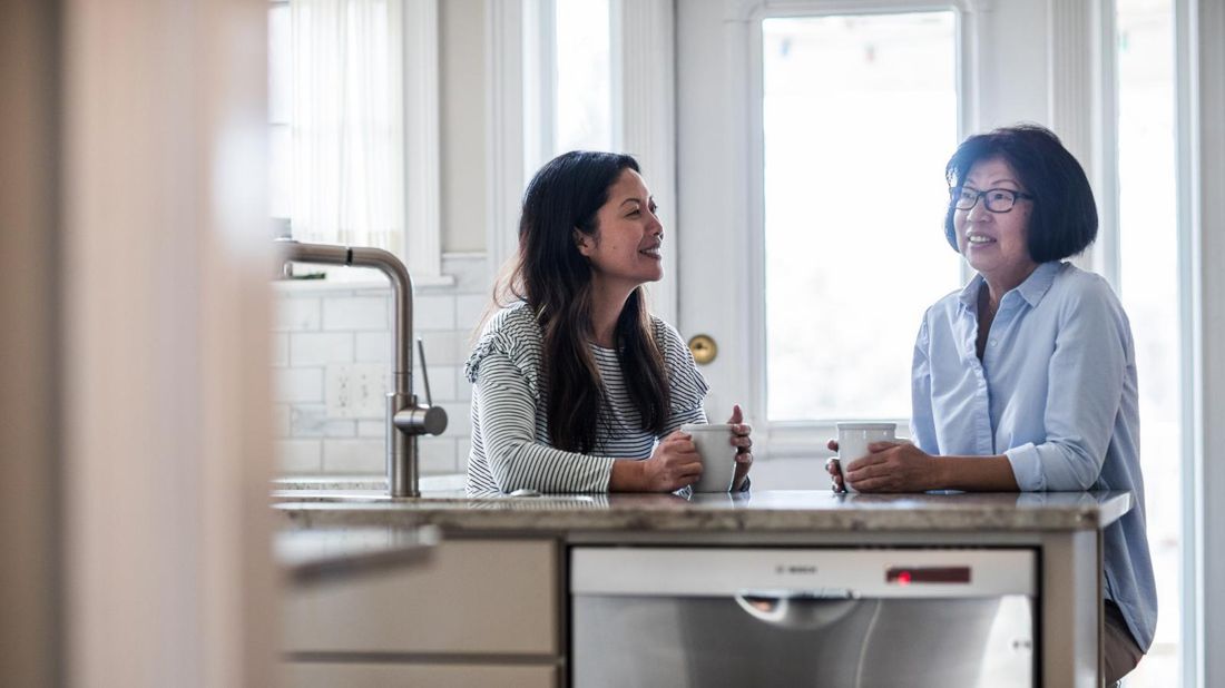 mother and daughter who has moved home in kitchen