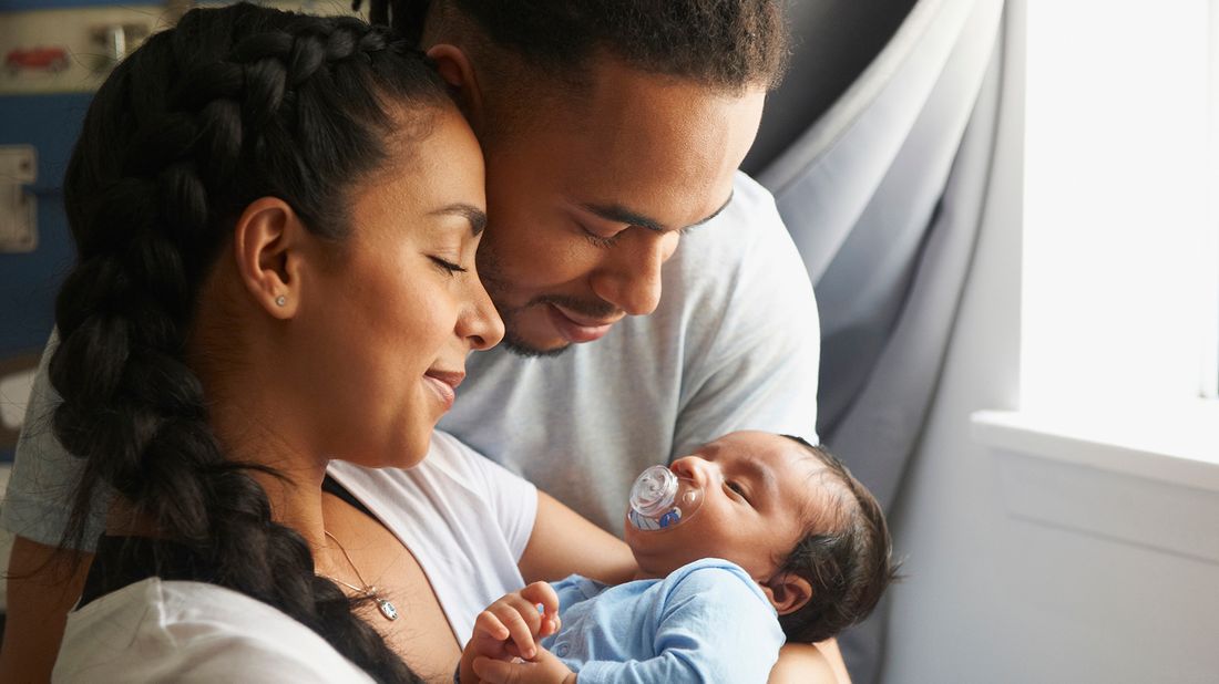 couple cradling newborn baby