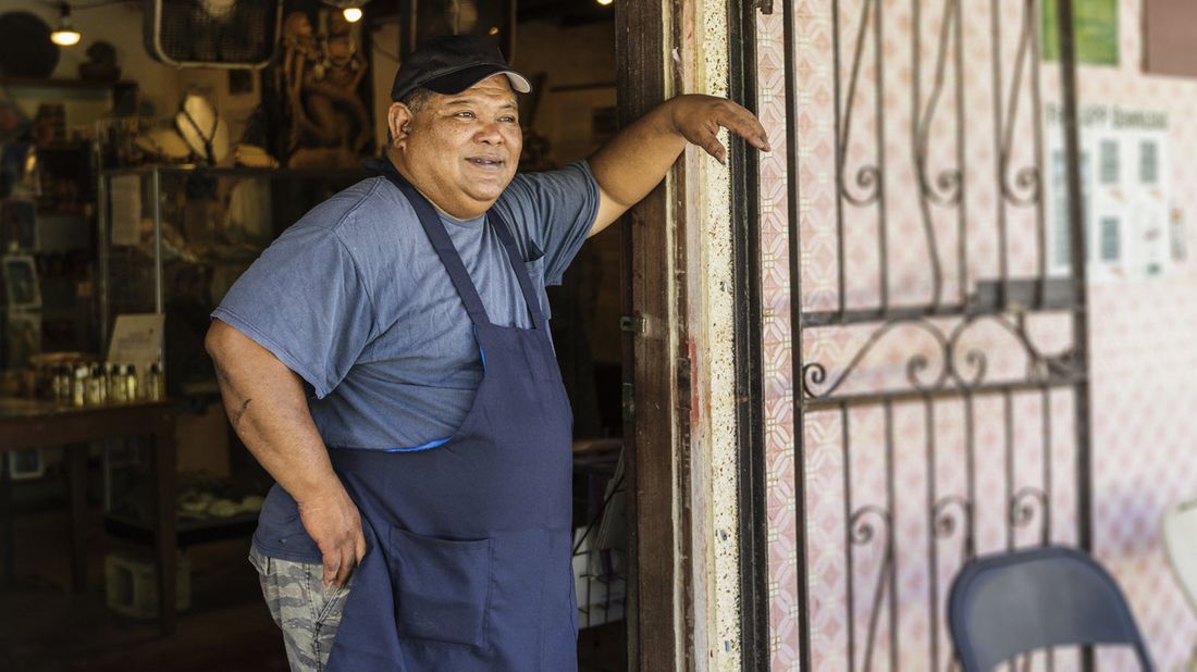 A business owner stands outside his business