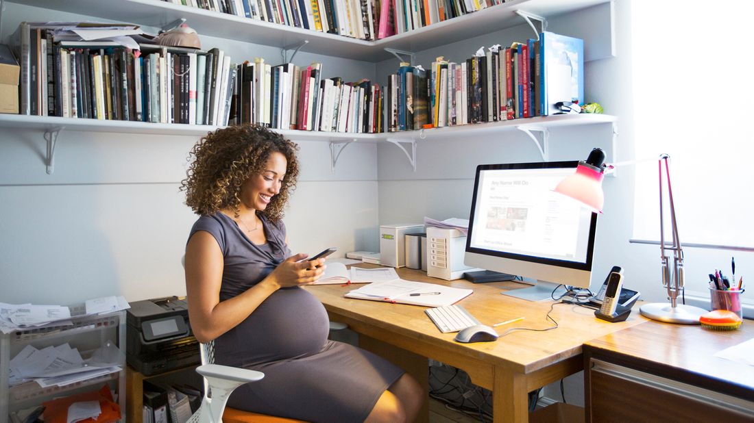 pregnant woman sitting at desk at home