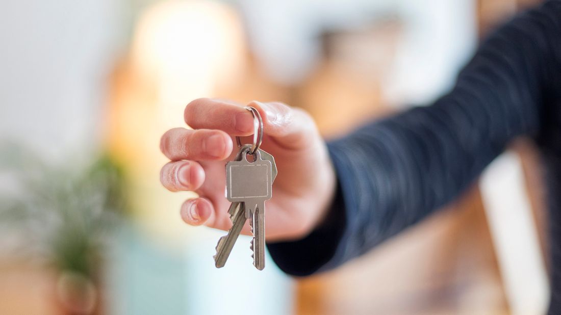 Man holding new house keys after getting mortgage while unemployed