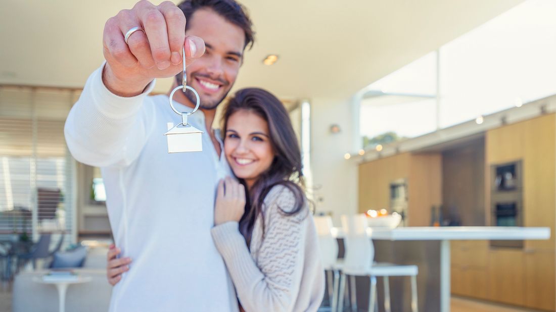 couple holding keys to their new home because they ignored mortgage misconceptions.