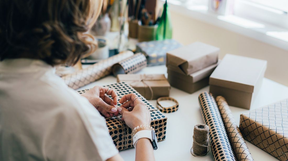 Woman wrapping gifts because she did holiday shopping early