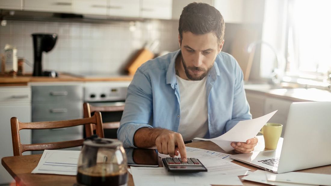 Man using a computer to figure out how to start an emergency fund