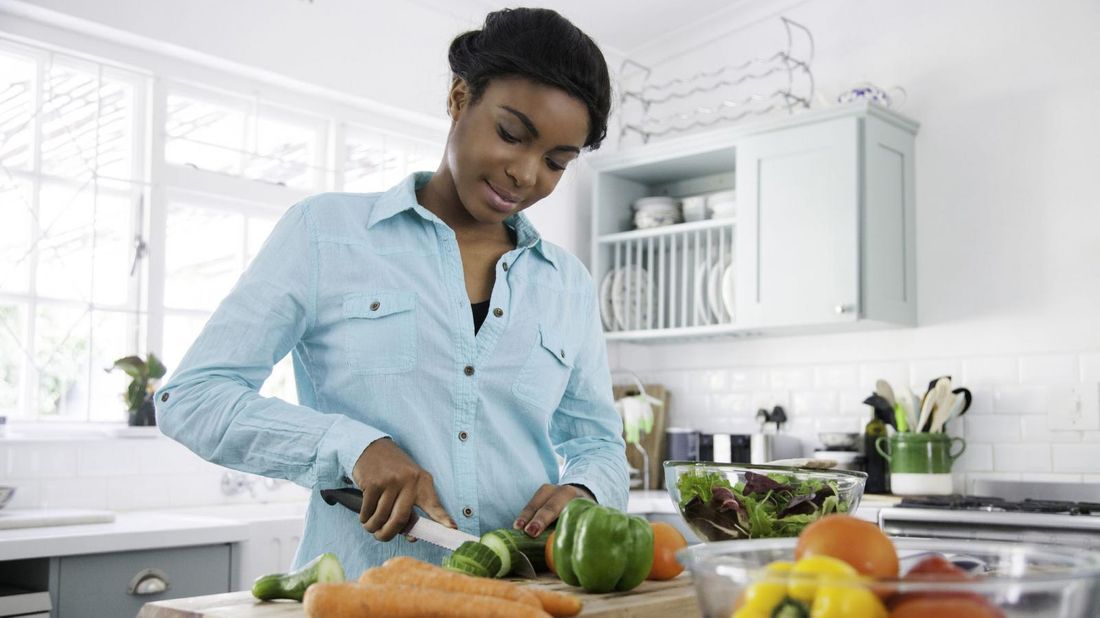 woman chopping veggies during quarantine for savings