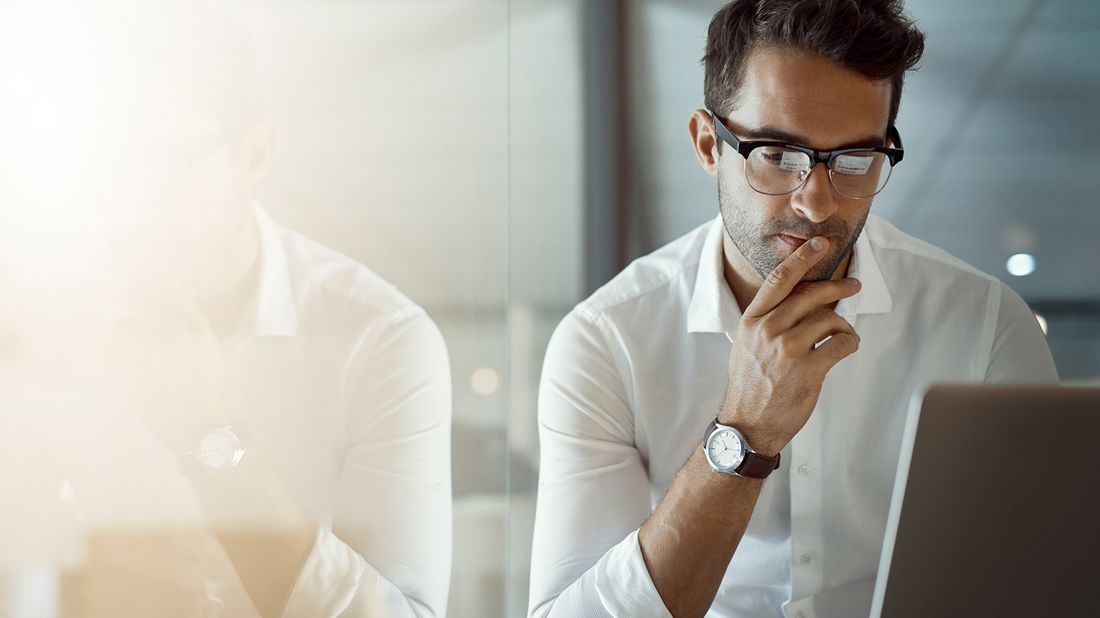 man looking at laptop wondering why his credit limit was lowered