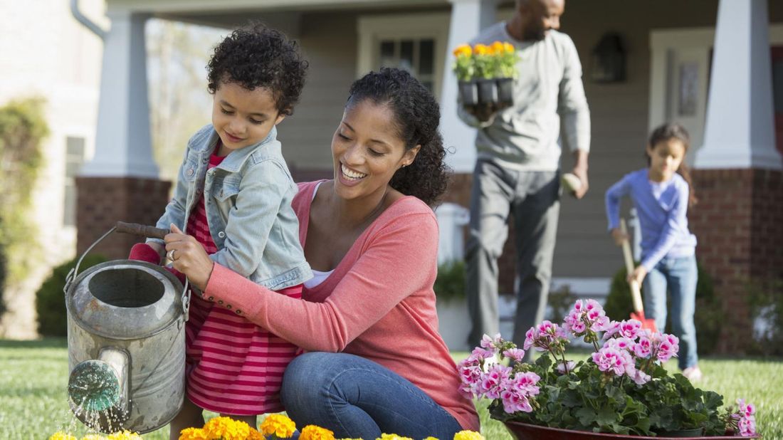 family with supplemental homeowners insurance watering flowers 