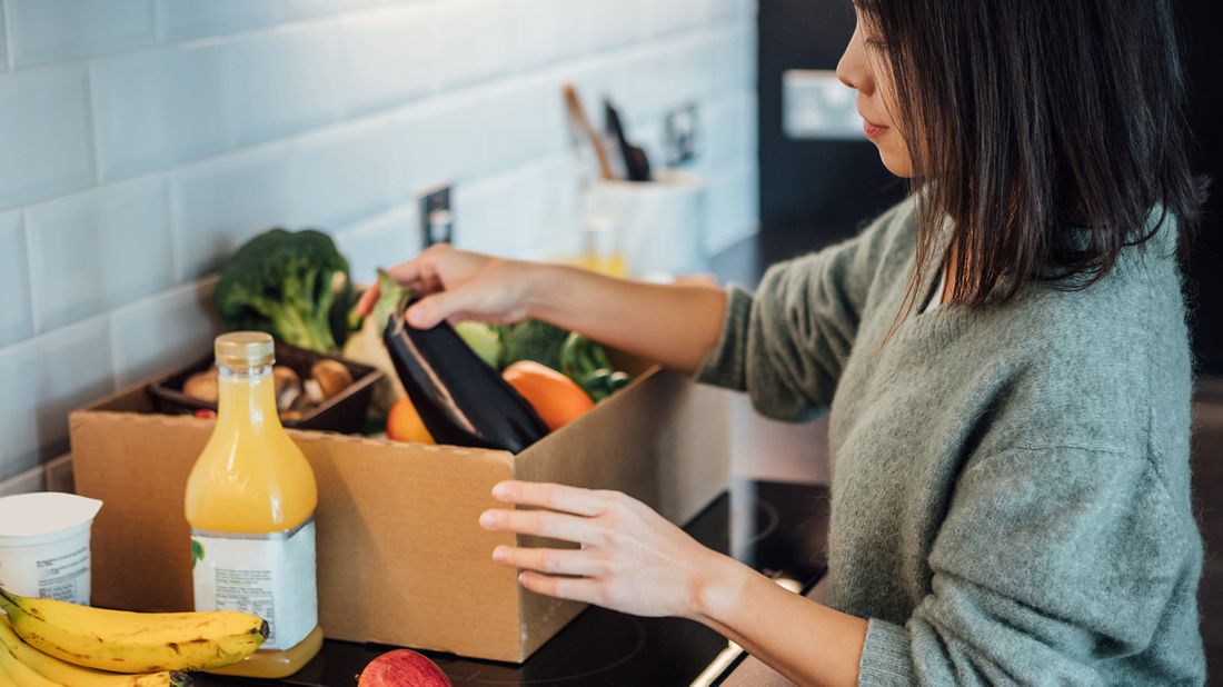 woman unpacking groceries at home