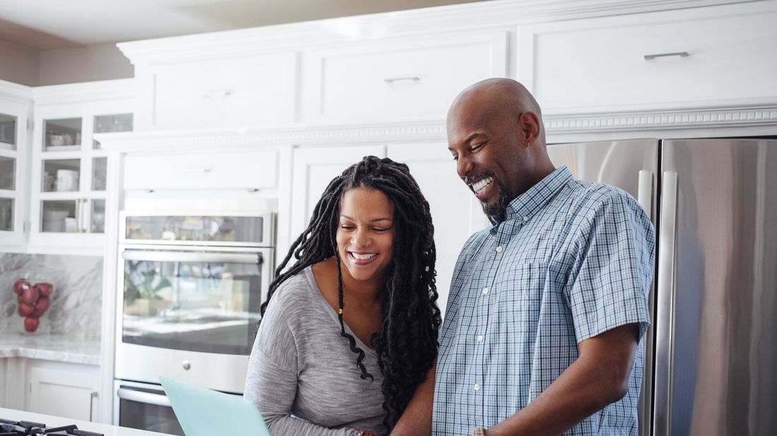 Couple in a kitchen researching what is the best age to buy an annuity 