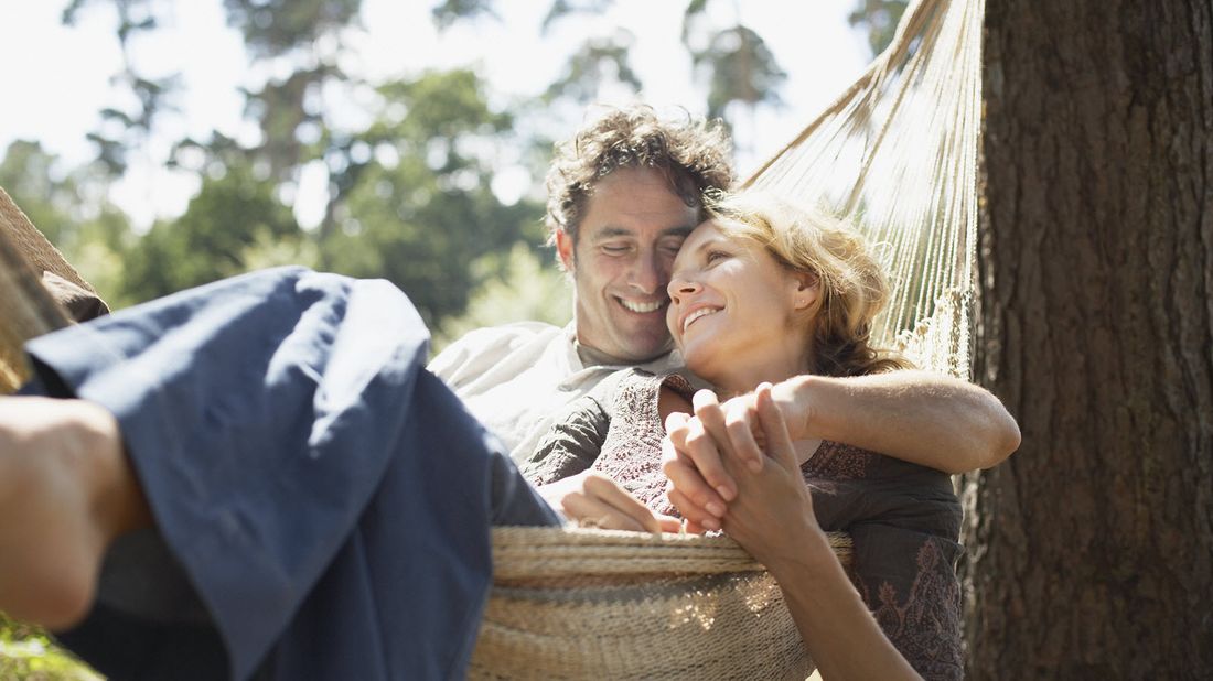 Couple snuggling in a hammock wondering if they need life insurance after 65