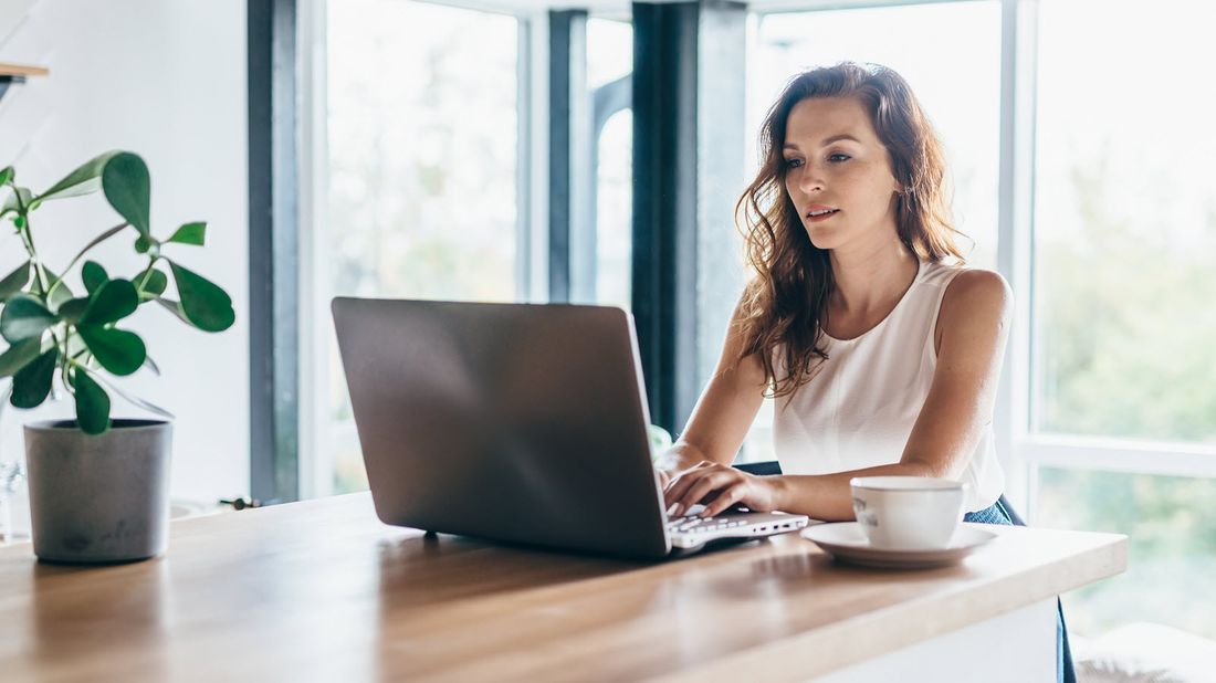 Woman drinking coffee and researching what does disability insurance pay for.