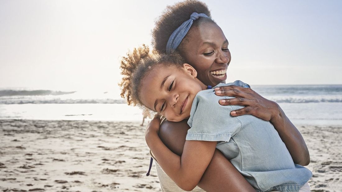 Mother with her daughter at the beach wondering how much is life and disability insurance.