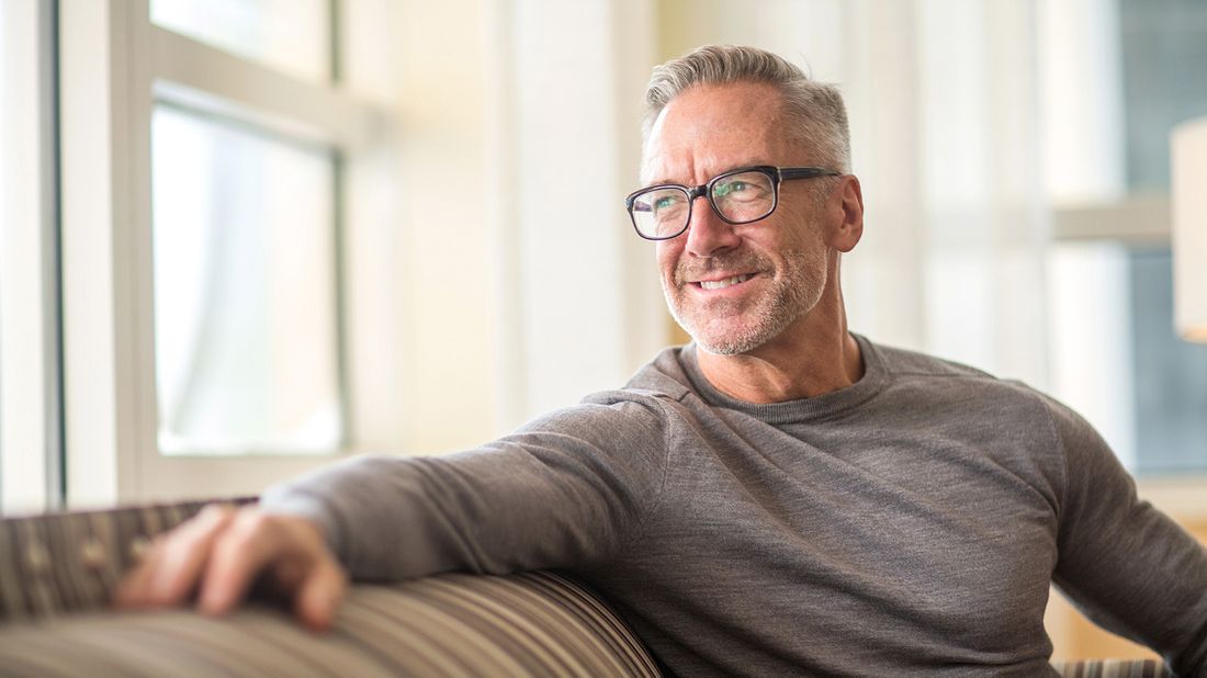 man sitting on sofa at home