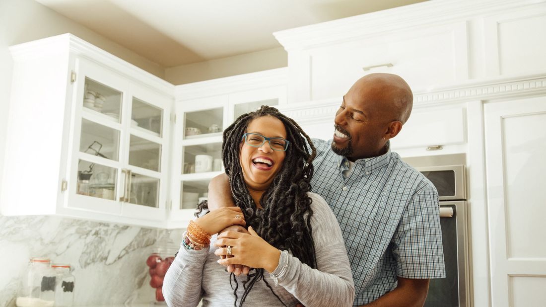 Couple in the kitchen talking about how much money they need to retire at age 50.