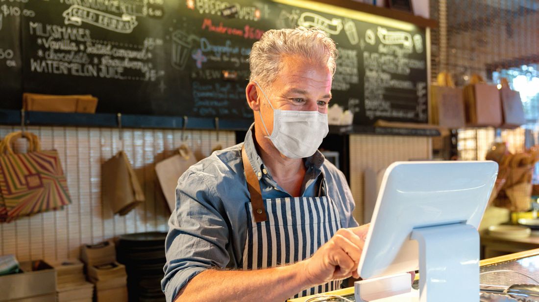 A store owner uses a payment terminal