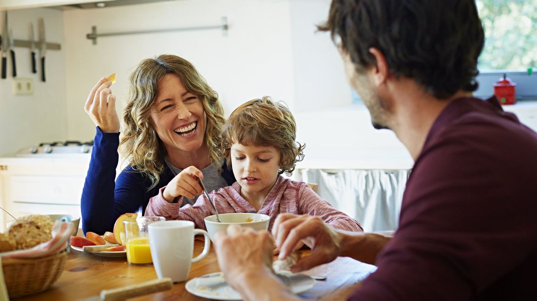 Mom and dad at the breakfast table discussing a financial planning checklist for a growing family