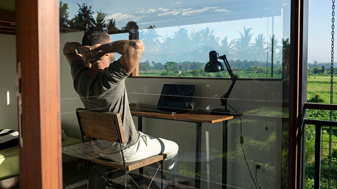 man sitting at desk looking at view