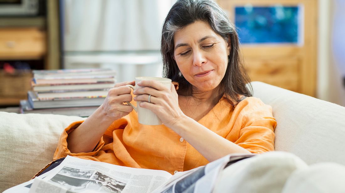 Woman reading newspaper about President Biden’s coronavirus relief package