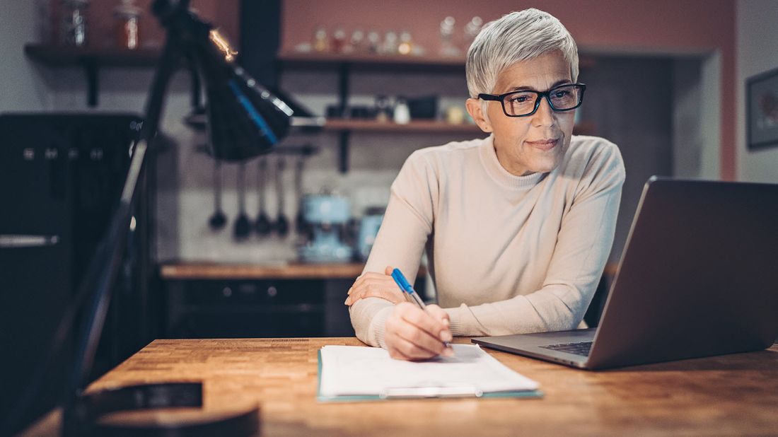 Woman looking at computer screen learning about tax-loss harvesting.