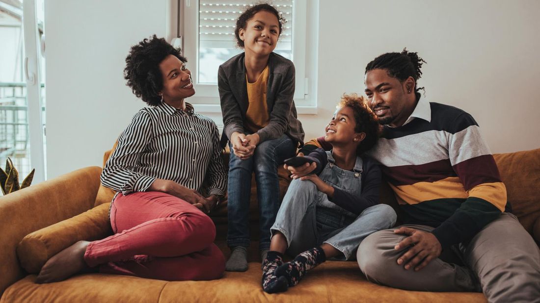 family on couch saving money