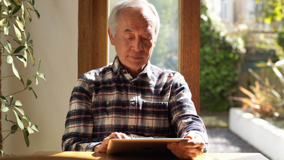 Man reading Northwestern Mutual Market Commentary on tablet