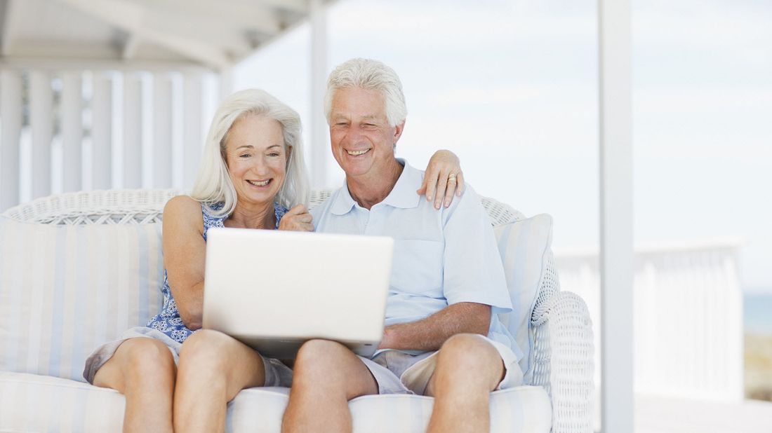 Couple sitting on porch reading Northwestern Mutual Market Commentary