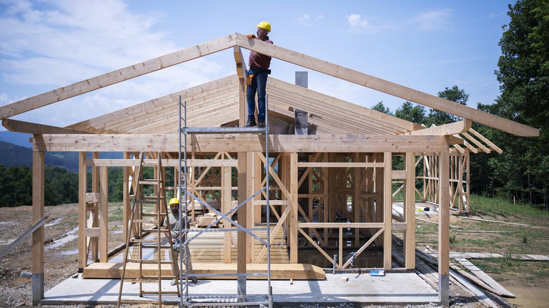 workers using lumber to construct the frame of a new home