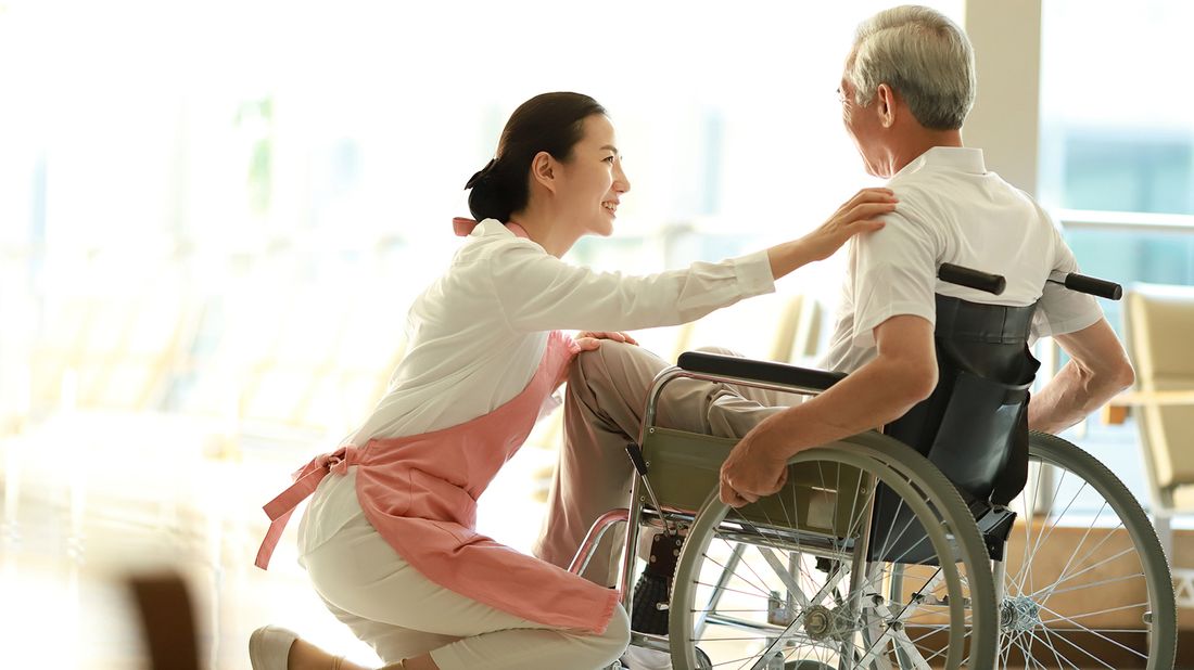 Home health aide helping a senior man with the activities of daily living.