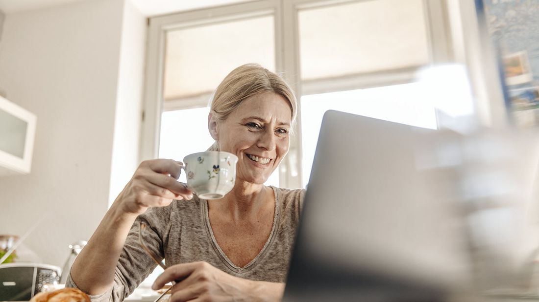 Woman drinking coffee and reading Northwestern Mutual Market Commentary