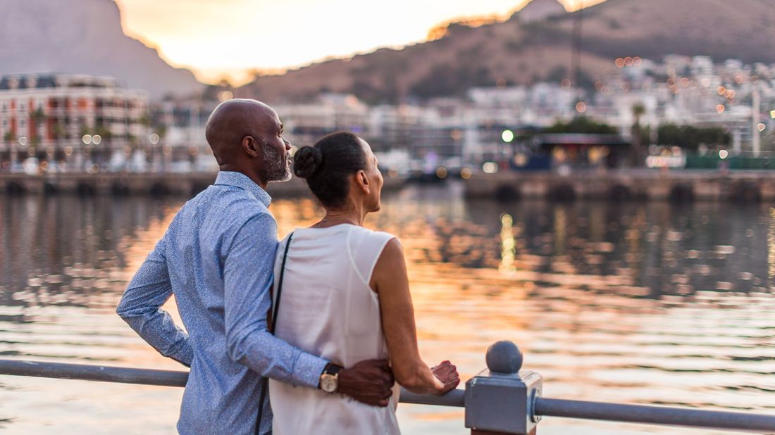 Couple standing along a river.