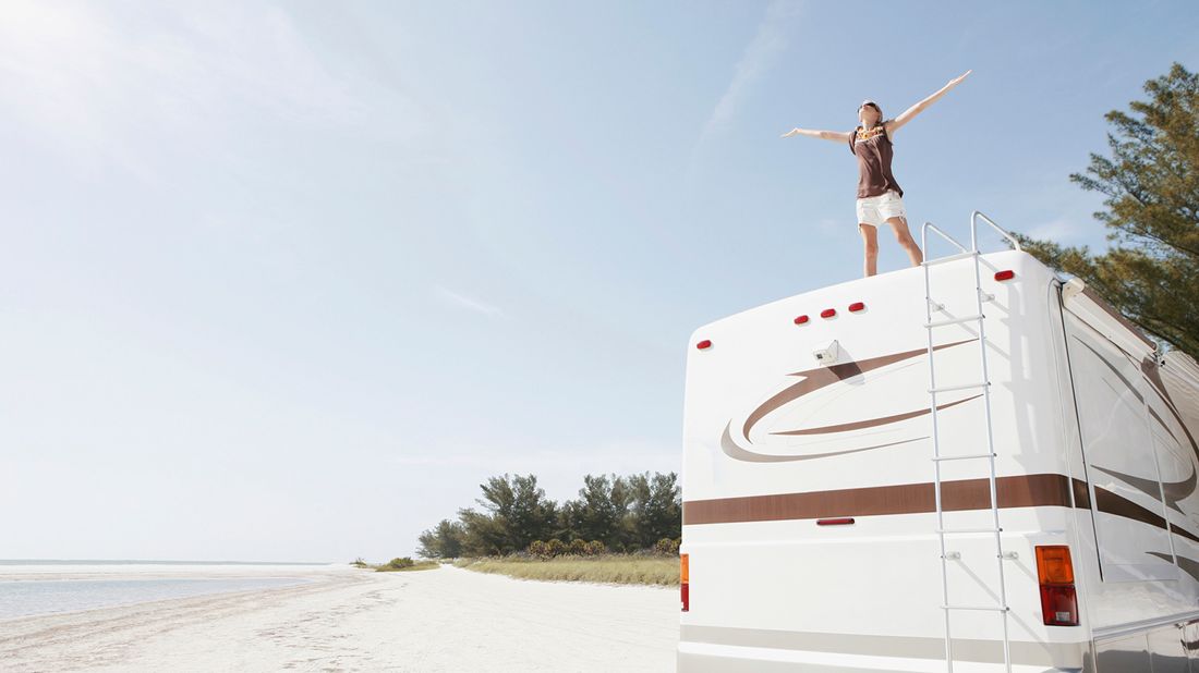 Woman standing on RV who needs RV camping tips