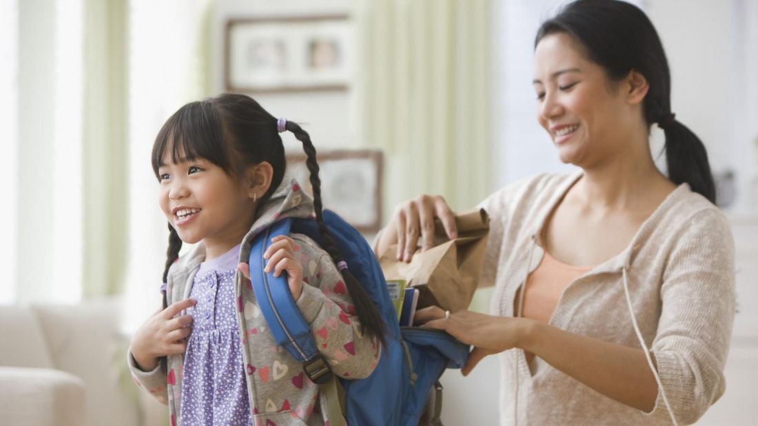 mom helping daughter get ready for school