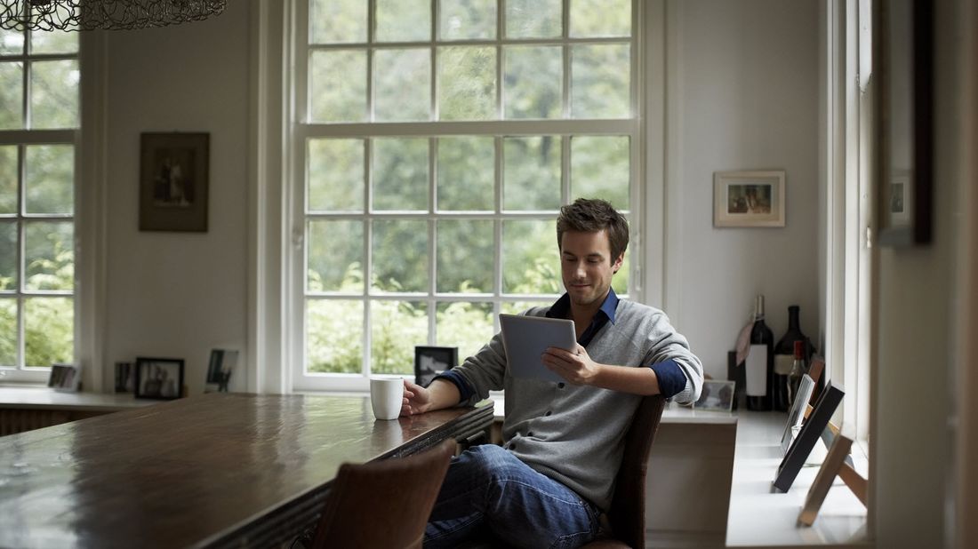 Man sitting at a table and reading Northwestern Mutual Market Commentary