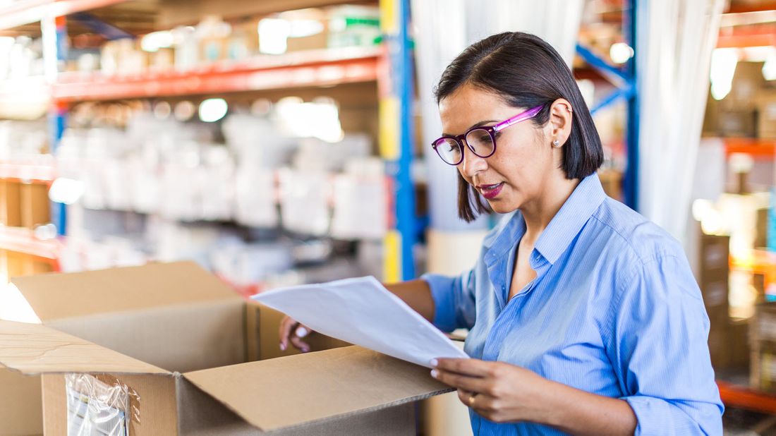 Business owner looking at shipment after reading Northwestern Mutual Market Commentary