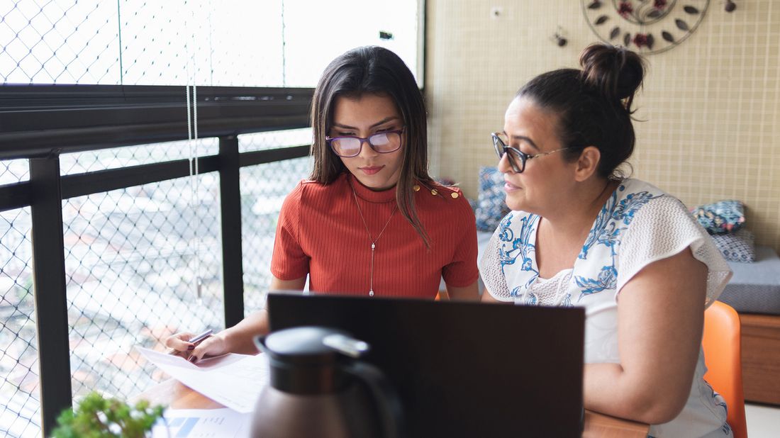 Mother and daughter at a desk researching what a private student loans