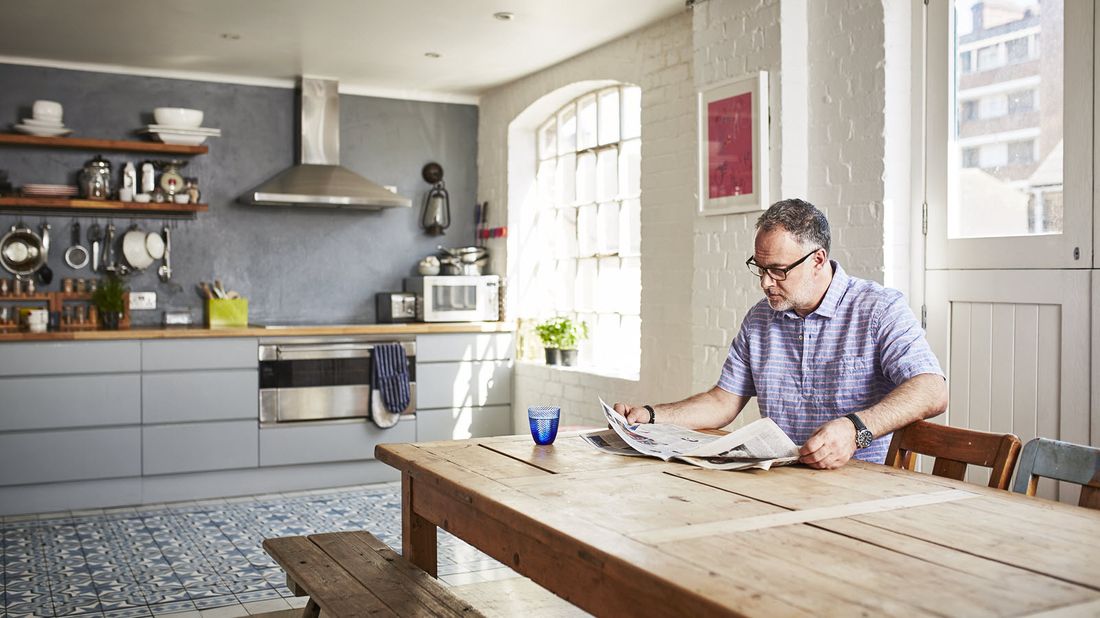 Man at a table reading newspaper