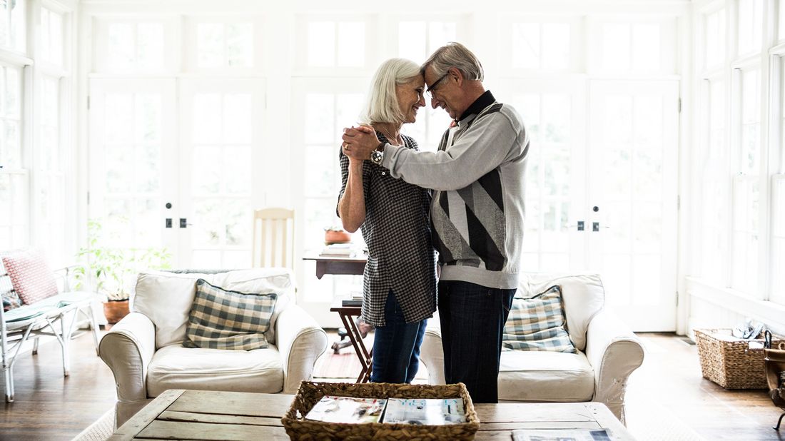 senior couple dancing in living room