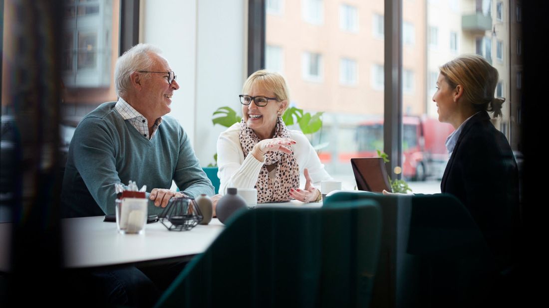 A retired couple talking to an advisor at an asset management company