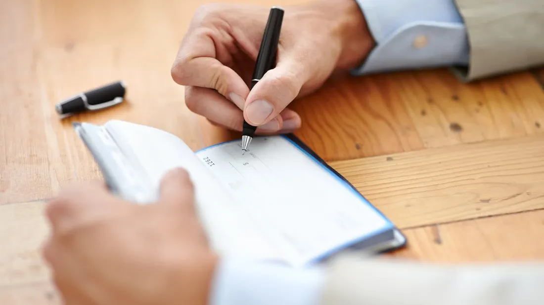 Donating Your Life Insurance to Charity man writing a check