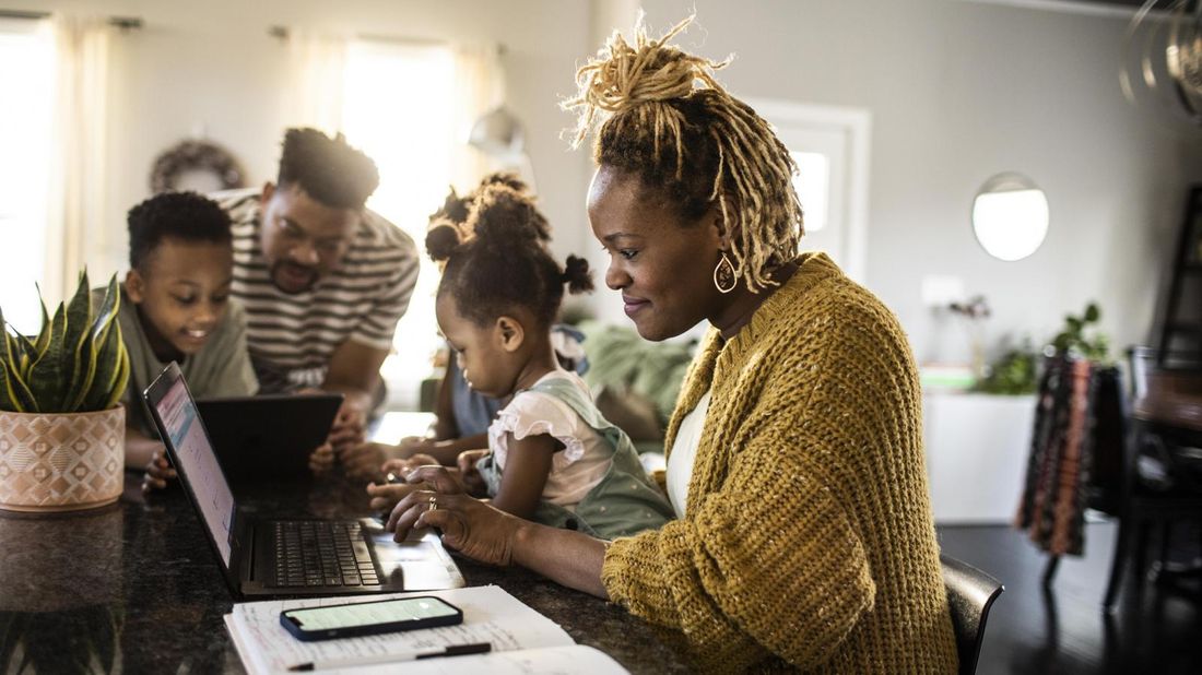 Mom with family in kitchen doing financial planning for families